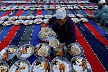 A man arranges plates of food for Iftar (breaking fast) meal during the fasting month of Ramadan, as the outbreak of the coronavirus disease (COVID-19) continues, at a mosque in Karachi, Pakistan. (Reuters)