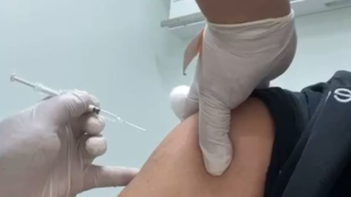 ممارس صحي آسيوي يعطي حقنة لقاح فارغة