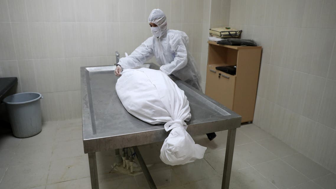 Employees wrap the body of a person who died of the COVID-19 disease at the morgue of Ortakoy cemetery in Ankara on February 23, 2021.