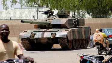 People drive past a Chad army tank near presidential palace, in N’djamena, Chad, on April 19, 2021. (Reuters)