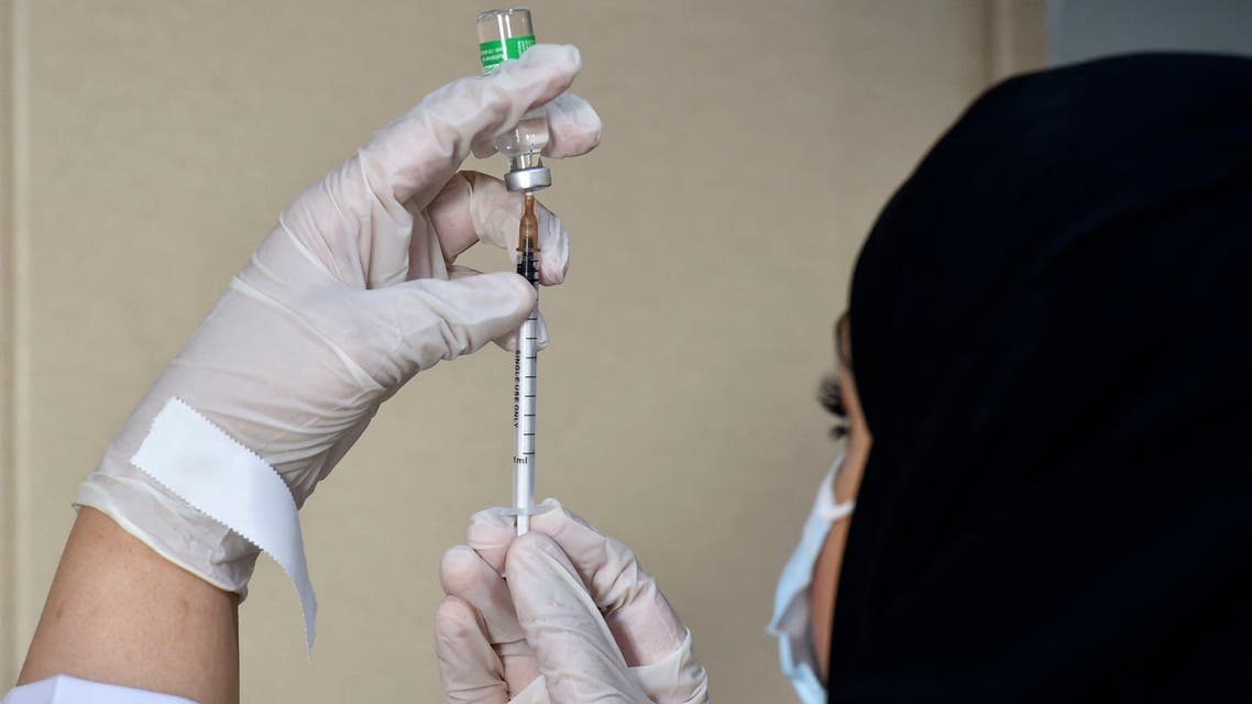 A medical worker displays a dose of the AstraZeneca COVID-19 vaccine at the first drive-through vaccination center in the Saudi capital Riyadh, on March 4, 2021.