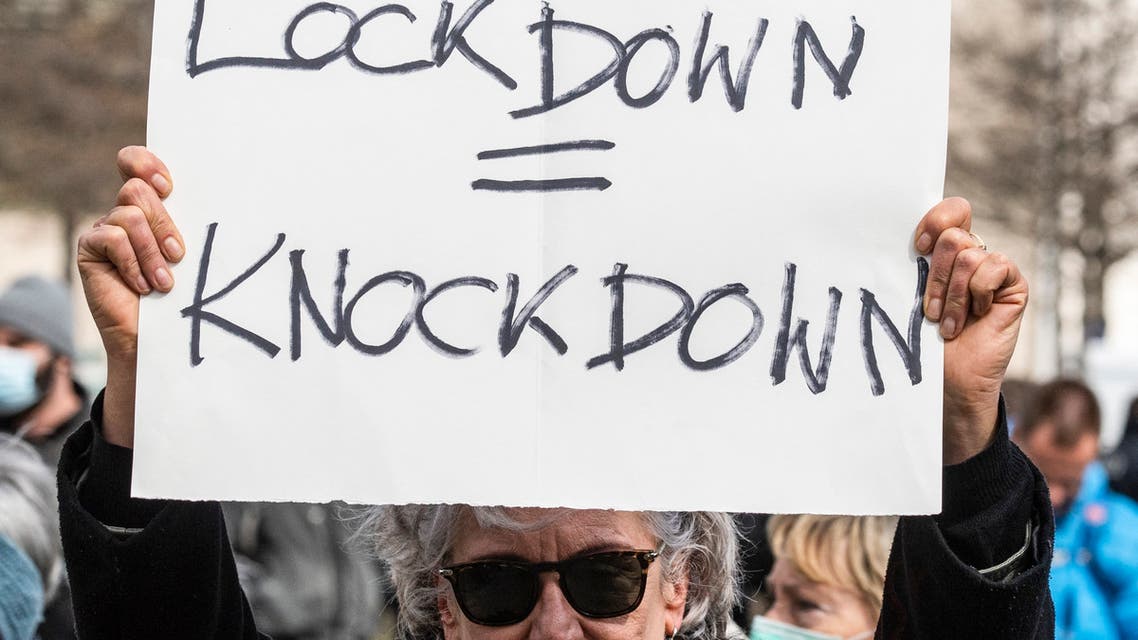 A demonstrator displays a placard reading Lockdown = knockdown during a demonstration by anti lockdown critics and so-called 'Querdenker' in Berlin on April, 13, 2021, amid the Covid-19, corona pandemic. (File photo: AFP)