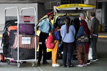 A porter loads the luggage of recently arrived air travelers from New Delhi, into a cab after Canada's government temporarily barred passenger flights from India and Pakistan for 30 days, at Vancouver International Airport in Richmond. (Reuters)