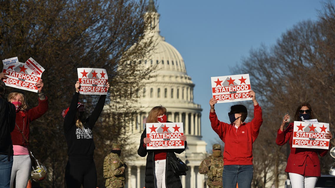 Activists hold signs as they take part in a rally in support of DC statehood near the US Capitol in Washington, DC on March 22, 2021. Democrats emboldened by their control of the US House, Senate and White House launched a fresh push Monday for statehood for the nation's capital Washington, beginning with a high-profile congressional hearing addressing the issue.