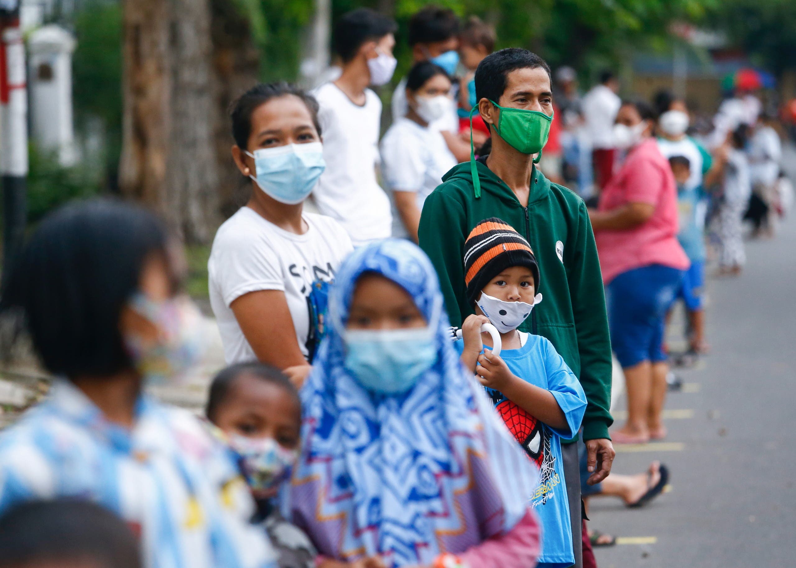 People wearing protective masks stand in line to receive a free meal to break the fast during the holy fasting month of Ramadan amid the coronavirus disease (COVID-19) pandemic in Jakarta, Indonesia, April 15, 2021. (File photo: Reuters)