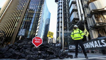 Activists from Extinction Rebellion, a global environmental movement, stand next to fake coal, made from rocks, during a protest outside the Lloyd's building in London, Britain April 23, 2021. (Reuters)