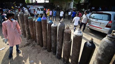 People wait to refill their medical oxygen cylinders for COVID-19 coronavirus patients at an oxygen refilling station in Allahabad on April 24, 2021. (Sanjay Kanojia/AFP)