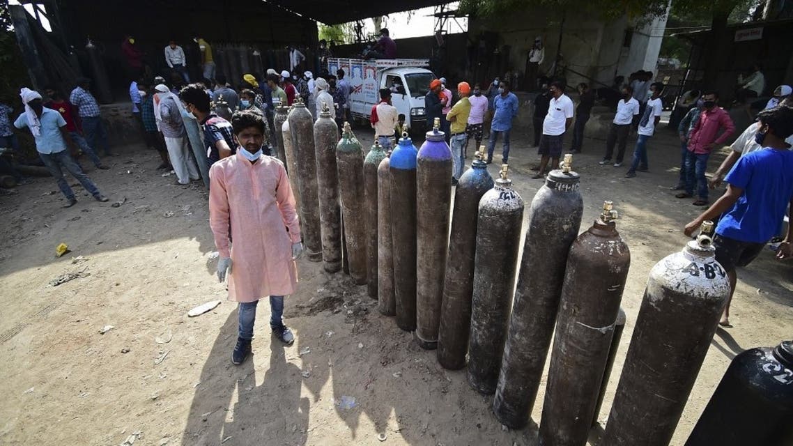 People wait to refill their medical oxygen cylinders for Covid-19 coronavirus patients at an oxygen refilling station in Allahabad on April 24, 2021. (AFP)
