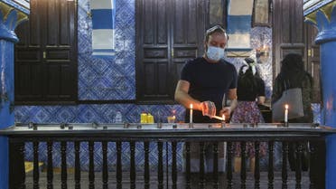 A Tunisian Jewish pilgrim lights a candle on the first day of the annual pilgrimage to the Ghriba Synagogue, the oldest Jewish monument built in Africa, on April 26, 2021 in the Mediterranean Tunisian resort island of Djerba. (Fathi Nasri/AFP)