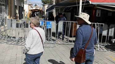 Tourists walks near the closed Ledra checkpoint of the UN-controlled buffer zone, after authorities declared the crossing temporarily shut to curb the spread of the coronavirus in Nicosia, Cyprus February 29, 2020. (Reuters/Yiannis Kourtoglou)