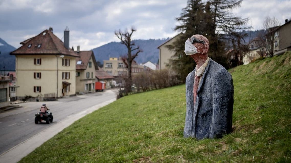 A picture taken on April 18, 2020 in Sainte-Croix shows a scultpure representing a man wearing a facemask as a preventive measure against the Covid-19 coronavirus in a field. (AFP)