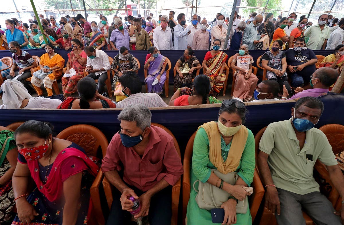 People wearing protective face masks wait to receive a vaccine for the coronavirus at a vaccination centre in Mumbai, India, on April 26, 2021. (Reuters)