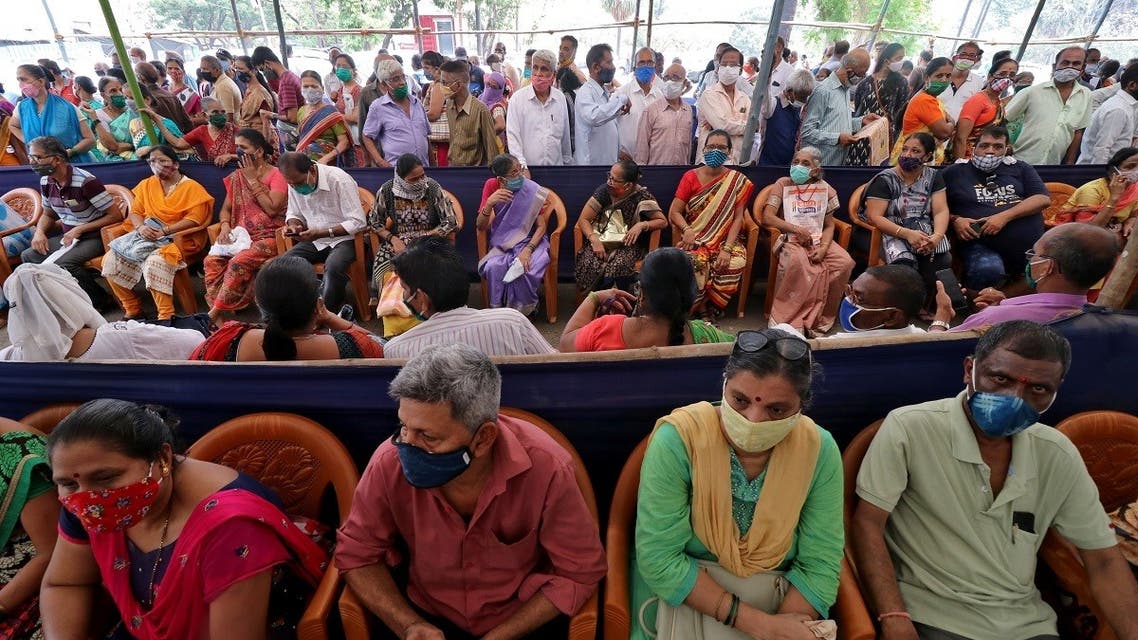 People wearing protective face masks wait to receive a vaccine for the coronavirus at a vaccination centre in Mumbai, India, on April 26, 2021. (Reuters)