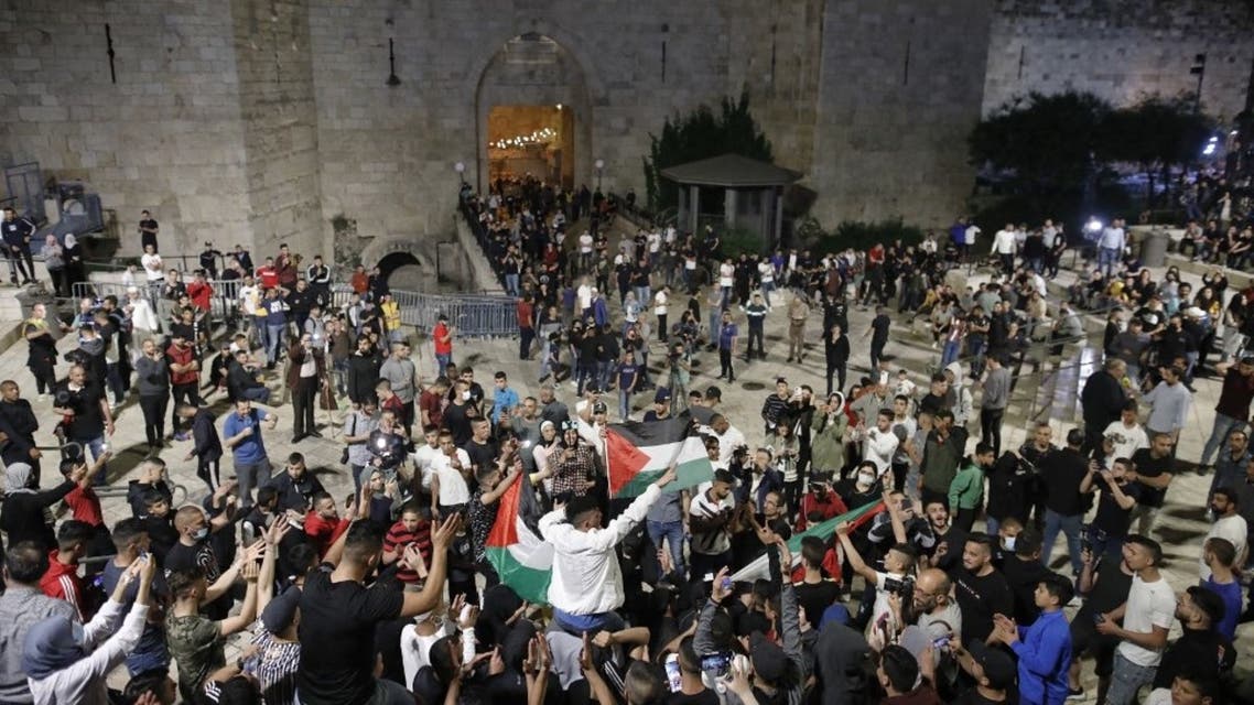 Palestinian protesters raise national flags as they gather near the Damascus Gate in Jerusalem's Old City, on April 25, 2021. (AFP)