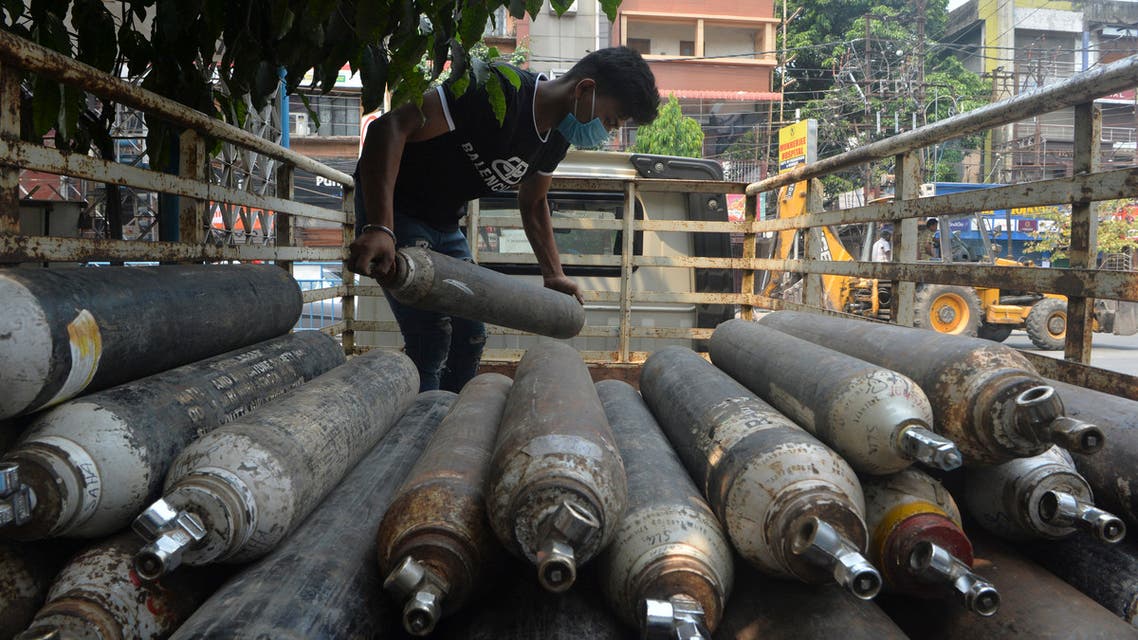 A man unloads empty oxygen cylinders for refill at an oxygen supply agency amidst rising Covid-19 coronavirus cases, in Siliguri on April 28, 2021. (File photo: AFP)