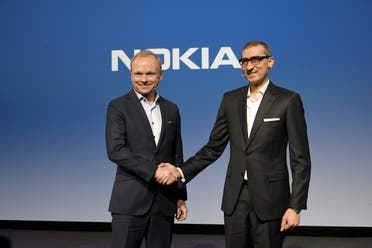 Nokia's new President and CEO Pekka Lundmark shakes hands with resigning President and CEO Rajeev Suri (R) after a news conference at the Nokia headquarters in Espoo, Finland, on March 2, 2020. (Reuters)
