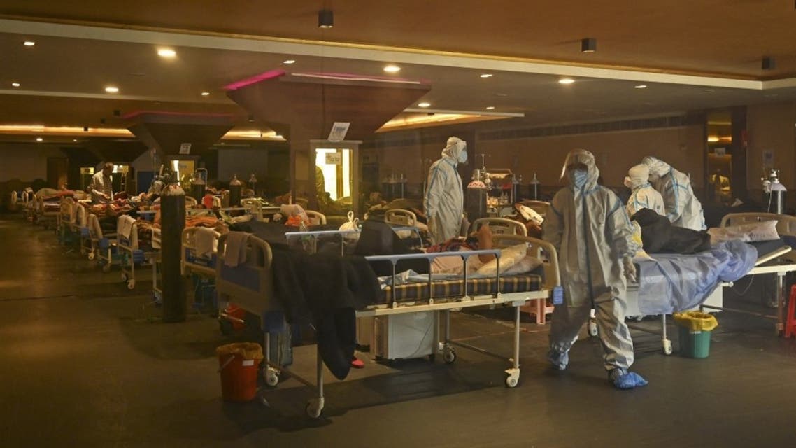 Health workers wearing personal protective equipment (PPE kit) attends to Covid-19 coronavirus positive patients inside a banquet hall temporarily converted into a covid care centre in New Delhi on April 29, 2021. (AFP)
