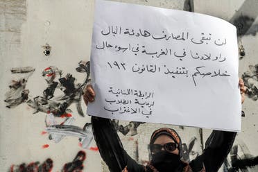 أولادنا في الغربة.. متظاهرة ترفع لافتة في لبنان (فرانس برس)