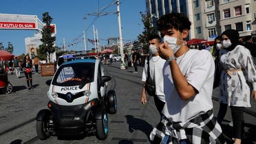 A member of Tourism Police sitting in a car patrols against people not wearing protective face masks at the main shopping and pedestrian street of Istiklal as the spread of the coronavirus continues, in Istanbul, Turkey, on September 27, 2020. (Reuters)
