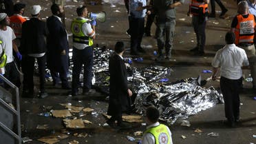 ltra-Orthodox Jewish men stand next to covered bodies after dozens of people were killed and others injured after a grandstand collapsed in Meron, Israel, where tens of thousands of people were gathered to celebrate the festival of Lag Ba'omer at the site in northern Israel early on April 30, 2021. (File photo: AFP)