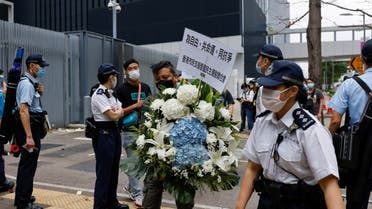 Police monitor a pro-democracy activist carrying a wreath of flowers to mourn those killed during the military crackdown on pro-democracy protesters at Beijing's Tiananmen Square in 1989, at the Qing Ming festival, or Tomb Sweeping Day, in Hong Kong, China April 4, 2021. (File photo: Reuters)