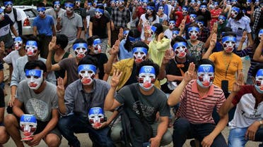This handout from the Burma Associated Press (BAP) taken and received on April 4, 2021 shows protesters making the three-finger salute while wearing masks that express what they say is Chinese interference in the UN's handling of Myanmar affairs after the military coup in Yangon's Kamayut township. (AFP)