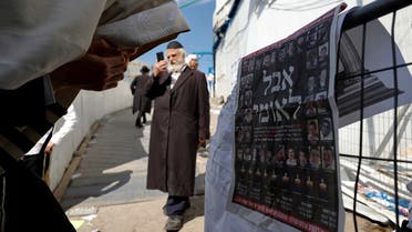 Ultra-Orthodox Jewish man reacts in front of a newspaper’s front page with the Hebrew words “National Mourning,” at the site of the religious festival at Mount Meron, Israel May 2, 2021. (Reuters/Amir Cohen)