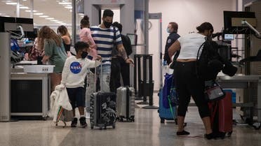 A family wears face masks as they pass security at Terminal A of IAH George Bush Intercontinental Airport amid the coronavirus outbreak in Houston, Texas, US, July 21, 2020. (Reuters/Adrees Latif)