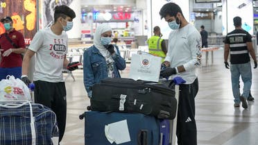 Repatriated Kuwaitis from Amman, wearing protective face masks, following the outbreak of the coronavirus disease (COVID-19), prepare their luggage while arriving at Kuwait Airport, Kuwait April 21, 2020. (Reuters)