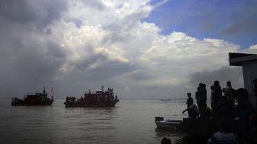 Bangladeshi rescue teams search the water as onlookers gather where an overloaded ferry capsized in the Padma river in Munshiganj, some 30 kilometres south of the capital Dhaka, on August 6, 2014. The owner and captain of a heavily overloaded river boat that sank in Bangladesh are facing criminal charges over the disaster, in which more than 130 people are feared drowned. The ferry was only licensed to carry 85 passengers, but had more than 200 on board when it went down in rough conditions in Munshiganj, around 30 kilometres (20 miles) south of Dhaka, on August 4, 2014. Police said they had launched a manhunt for the owner of the vessel, which rescue workers have still not been able to locate, more than 48 hours after the disaster. AFP PHOTO/Munir uz ZAMAN