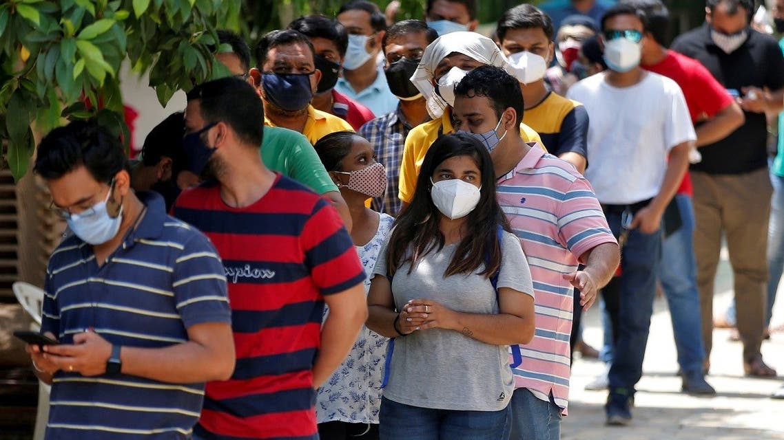 People wearing protective face masks wait to receive a dose of COVISHIELD, a coronavirus  vaccine manufactured by Serum Institute of India, outside a vaccination centre in Ahmedabad, India, on May 1, 2021. (Reuters)