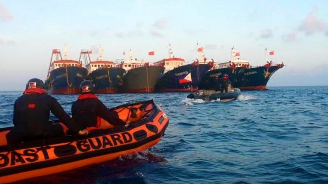 Members of the Philippine Coast Guard use rubber boats as they patrol beside Chinese vessels moored at Whitsun Reef, South China Sea on April 14, 2021. (AP)