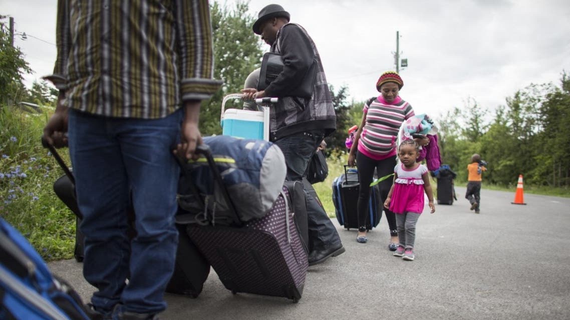 A long line of asylum seekers wait to illegally cross the Canada/US border near Champlain, New York on August 6, 2017. (File photo: AFP)
