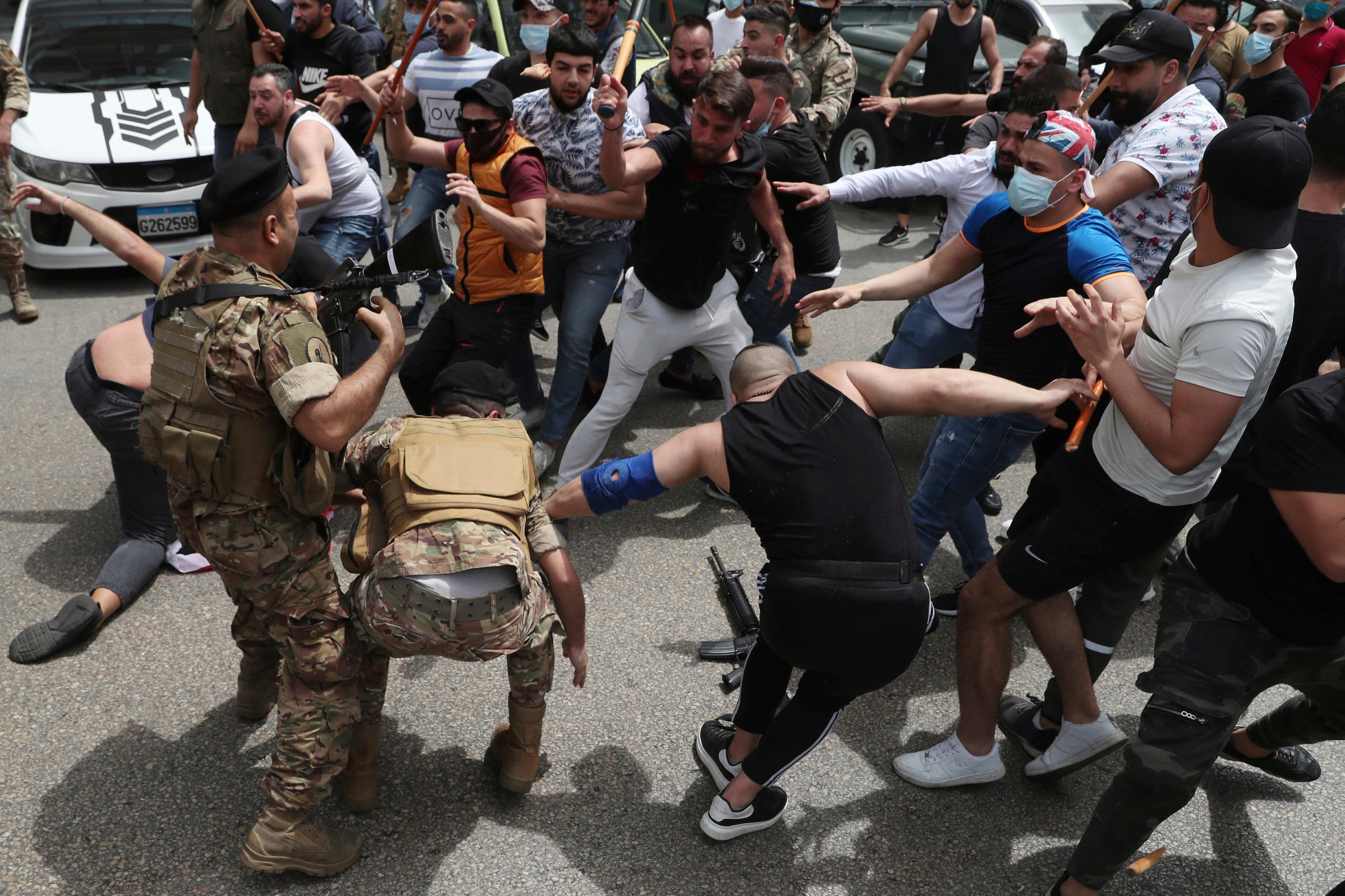 In this April 19, 2021 file photo, opponents of Judge Ghada Aoun try to strip an army soldier of his rifle as scuffles break out during a sit-in outside the Justice Palace, in Beirut, Lebanon. (AP)