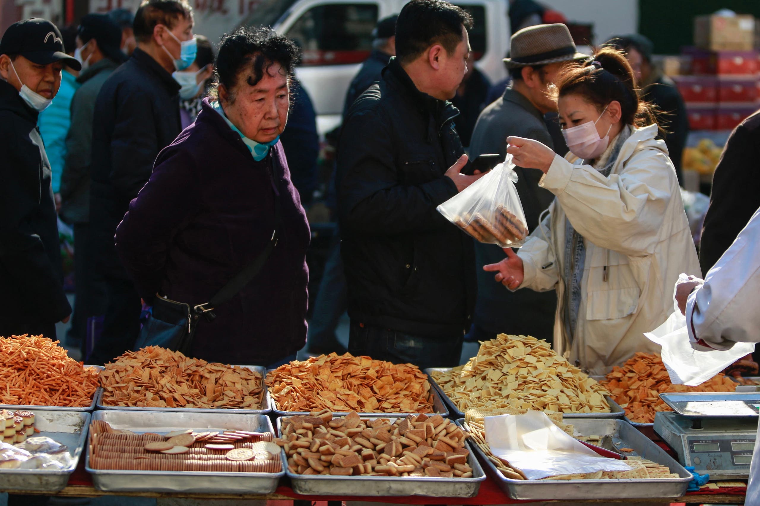 سيدة تشتري المأكولات من سوق في مدينة ليوانينغ الصينية (تعبيرية*