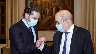 A handout picture provided by the Lebanese photo agency Dalati and Nohra on May 6, 2021 shows Lebanon's prime minister-designate Saad Hariri (L) fist-bumping French Minister for Foreign and European Affairs Jean-Yves Le Drian (R) during their meeting in the capital Beirut. (File photo: AFP)