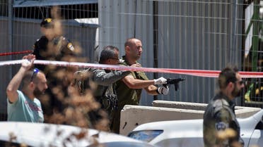 An IDF officer inspects the weapon used by a Palestinian gunmen at the scene of shooting attack in front of the military base of Salem near the West Bank town of Jenin, on May. 7, 2021. (Reuters)