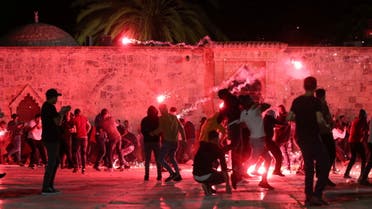 Palestinians react as Israeli police fire stun grenades during clashes at the compound that houses Al-Aqsa Mosque. (Reuters)