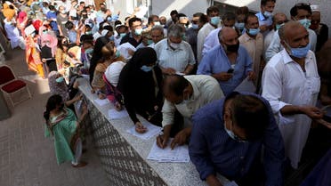 People stand in queues while they wait their turn to receive the first shot of the Sinopharm COVID-19 vaccine at a vaccination center in Karachi, Pakistan, Saturday, May 8, 2021. (AP/Fareed Khan)