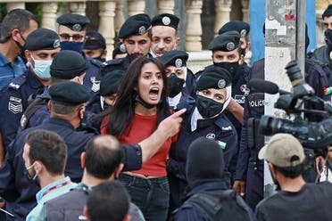 Police members restrain a demonstrator during a protest in solidarity with the Palestinian people near the Israeli embassy in Jordan’s capital Amman on May 9, 2021. (Khalil Mazraawi/AFP)