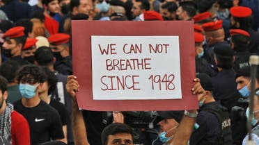 A man holds up a sign reading in English “we can not breathe since 1948” during a protest to express solidarity with the Palestinian people near the Israeli embassy in Jordan’s capital Amman on May 9, 2021. (Khalil Mazraawi/AFP)