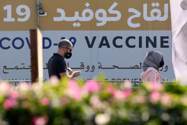 A man and a woman walk past a huge health ministry COVID-19 vaccines announcement outside a medical centre in Dubai on February 16, 2021, as the Gulf emirates goes ahead its vaccination effort. The UAE, home to a population of around 10 million, has administered some 4.6 million doses of vaccine, making it the second-fastest per capita delivery in the world, after Israel. (File photo: AFP)