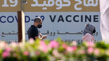 A man and a woman walk past a huge health ministry COVID-19 vaccines announcement outside a medical centre in Dubai on February 16, 2021, as the Gulf emirates goes ahead its vaccination effort. The UAE, home to a population of around 10 million, has administered some 4.6 million doses of vaccine, making it the second-fastest per capita delivery in the world, after Israel. (File photo: AFP)