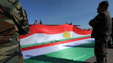 Members of the Iraqi Kurdish Peshmerga forces hold up a giant Kurdish flag as they commemorate the annual Kurdish Flag Day in Makhmur, about 280 kilometres (175 miles) north of the capital Baghdad, on December 17, 2019 in Iraq's autonomous Kurdistan region.