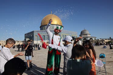 Muslim children celebrate in front of the Dome of the Rock mosque after the morning Eid al-Fitr prayer at the al-Aqsa mosques compound in Old Jerusalem early on May 13, 2021. (AFP)
