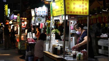 A woman wearing a protective face mask prepares food at her stall during the coronavirus disease (COVID-19) pandemic, in Taipei, Taiwan, May 11, 2021. (Reuters)