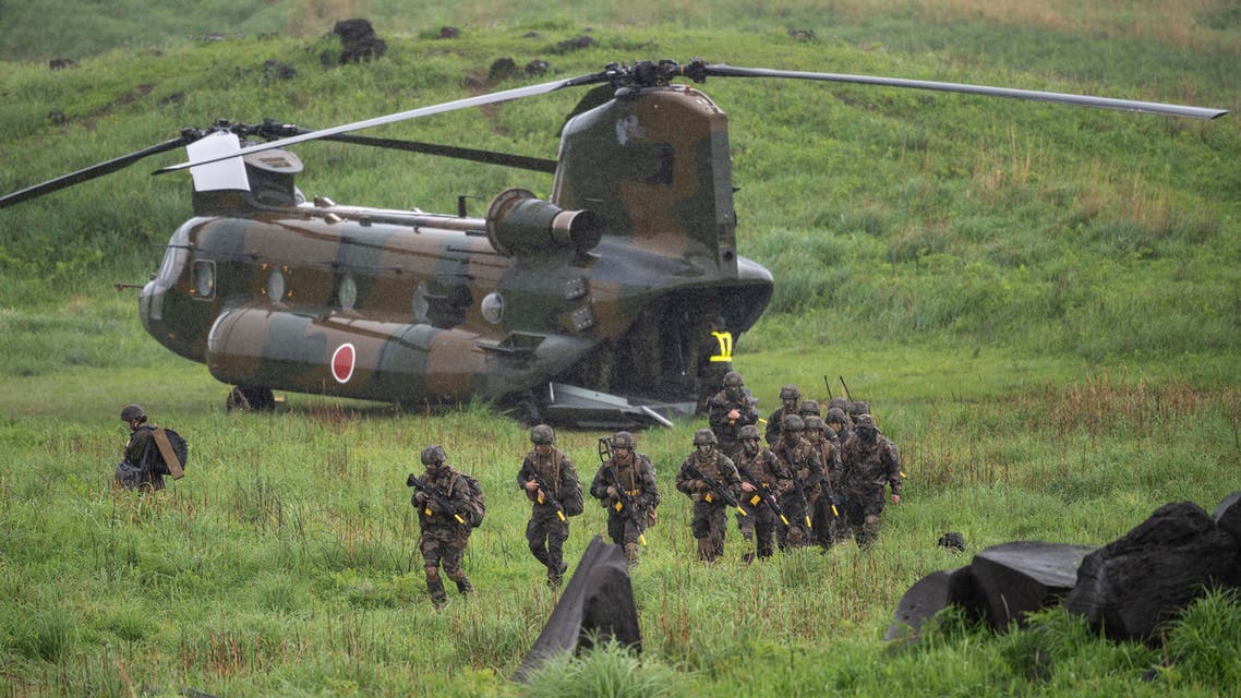  French army soldiers walk from a Chinook helicopter during a joint military drill between Japan Self-Defense Force, French army and U.S. Marines, at the Kirishima exercise area in Ebino, Miyazaki prefecture, southern Japan Saturday, May 15, 2021. (Charly Triballeau/Pool Photo via AP)