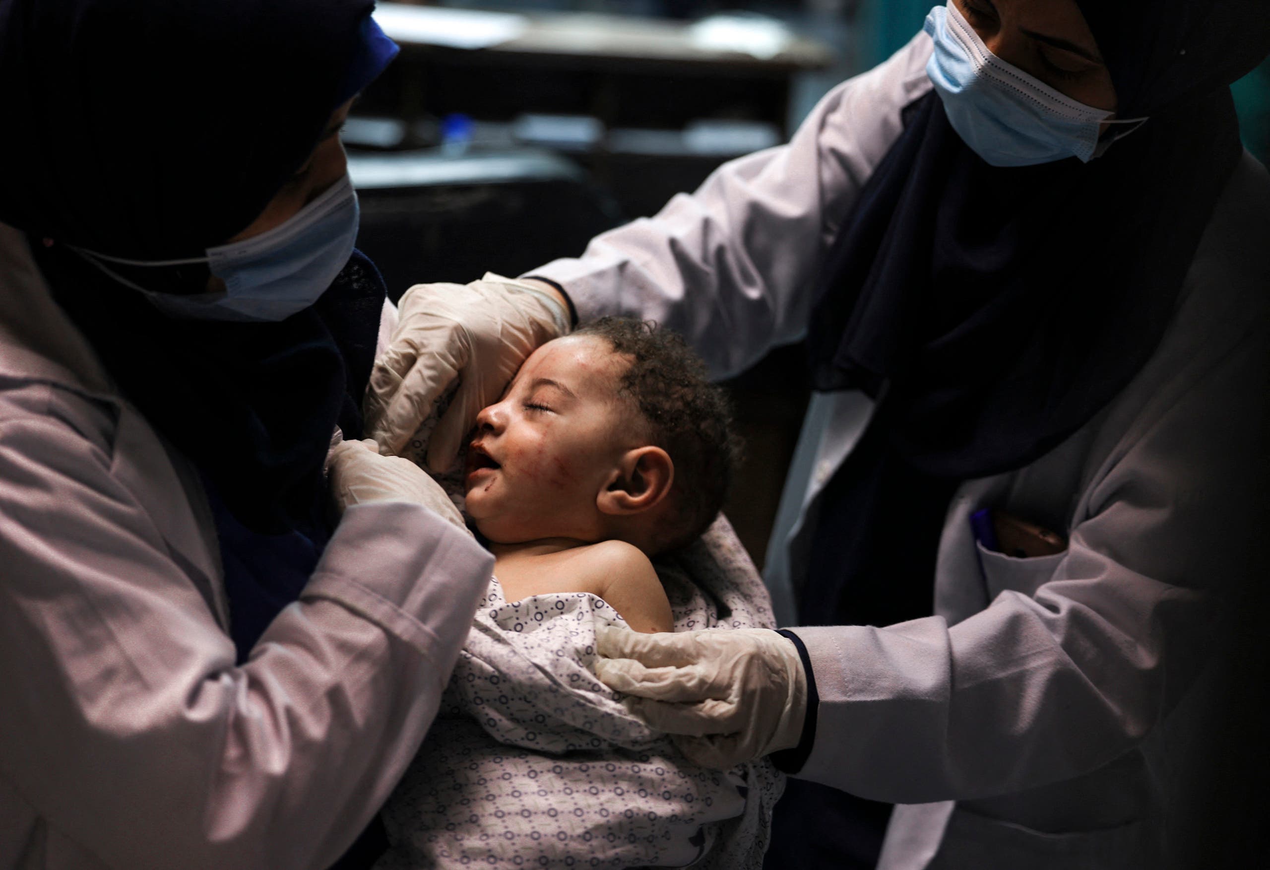 A nurse holds a baby, who was pulled alive from under the rubble while seven other family members perished, at Al-Shifa Hospital, after an Israeli air strike struck al-Shati Refugee Camp without advance warning during the night, in Gaza City early on May 15, 2021. (AFP)