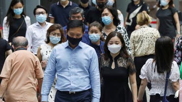 Office workers wearing masks cross a street during lunch hour, amid the coronavirus disease (COVID-19) outbreak, in Singapore May 12, 2021. (Reuters)