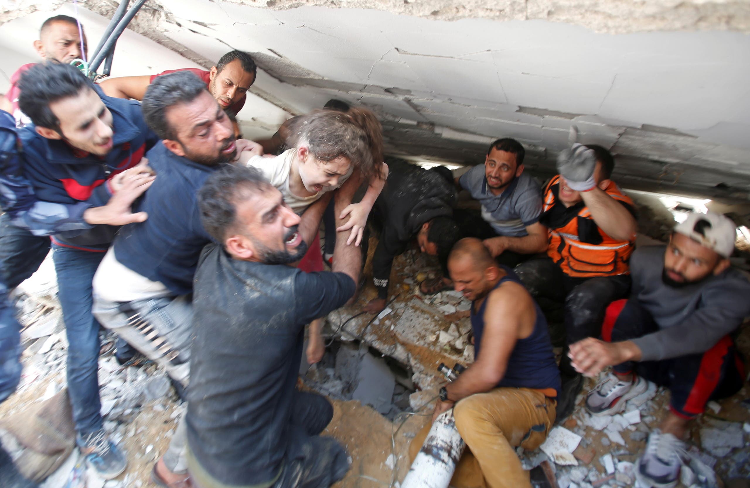 Rescuers carry a girl as they search for victims amid rubble at the site of Israeli air strikes, in Gaza City May 16, 2021. (Reuters)